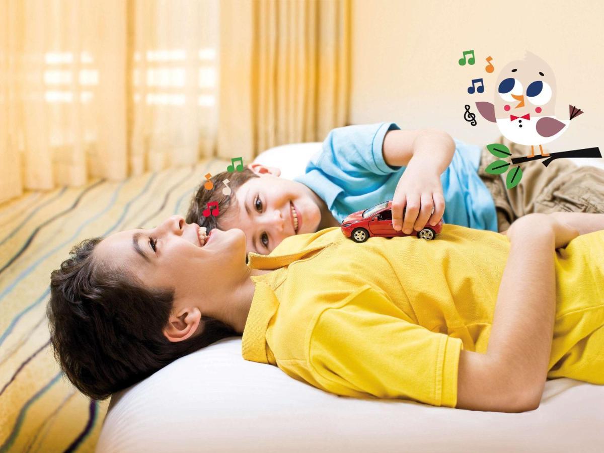Movenpick Jumeirah Village Triangle Dubai Esterno foto A child with autism playing with a toy car