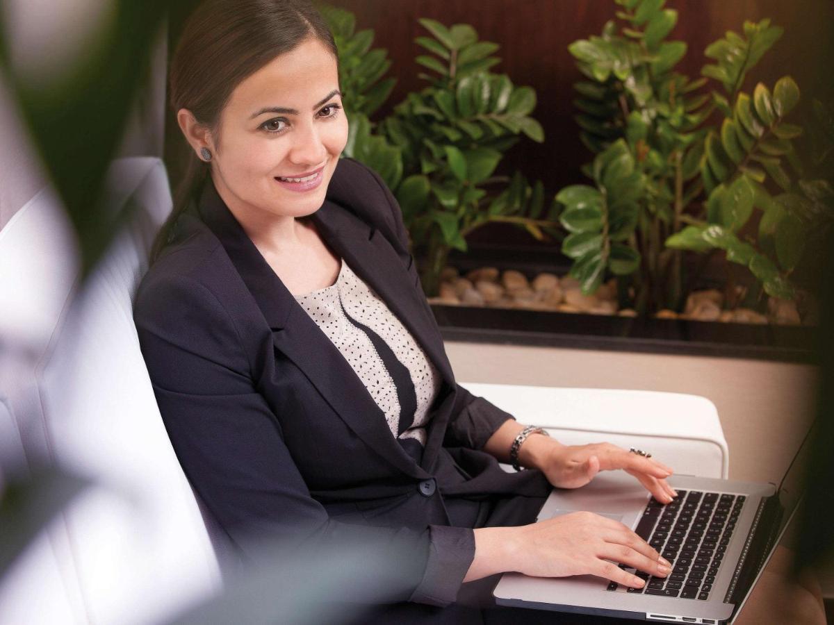 Movenpick Jumeirah Village Triangle Dubai Esterno foto A business woman working on a laptop